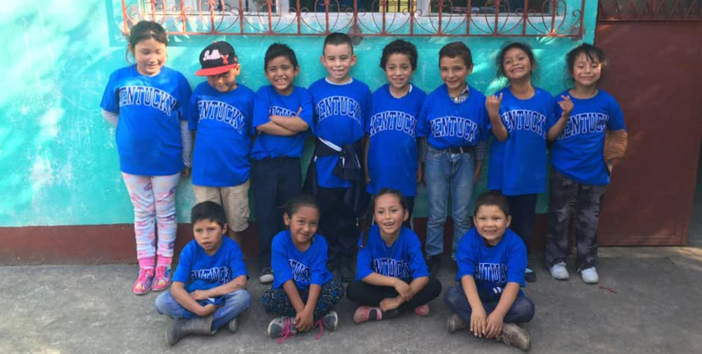 12 children at The Little Mountain School, all wearing blue University of Kentucky t-shirts