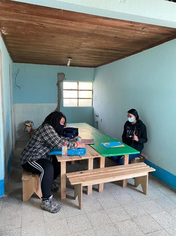 Two women sitting across from one another at a table